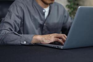 Focused Individual Working on Laptop in Modern Workspace Environment photo