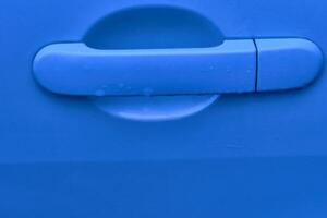 Evening blue car handle with lock, key hole after rain photo