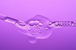 Two pipettes with serum on a lilac background. The texture. photo