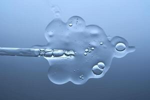 The texture of a serum with microneedles and a cosmetic pipette on a blue background. photo