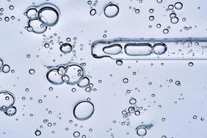 The bubbly texture of a face serum with a pipette. View from below. photo