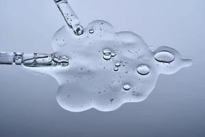 Hydrolyzed sponge serum with a pipette on a gray background. photo
