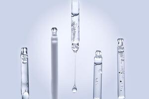 Five different droppers with facial serum in a row. photo