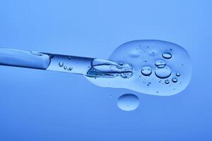 Serum with peptides on a blue background with a pipette. The texture. photo
