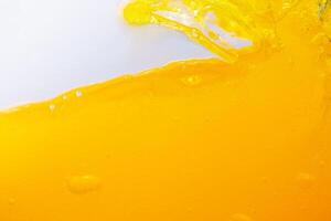Close up bright orange juice splash texture for health and nature waves, Beautiful waves curve and little bubbles smooth for garphic design and backgr photo