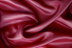 Dark red silk with soft curves and vibrant reflective surface. Suitable for design and wallpaper background photo