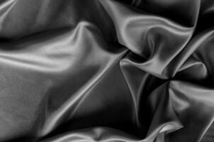 Top view of dark satin fabric with rich texture and smooth, elegant folds. Suitable for design and wallpaper background photo