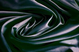 Top view of polished dark grey silk cloth with silky sheen and beautiful natural draping. Suitable for design and wallpaper background photo