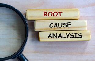 Top view of Root Cause Analysis text on wooden blocks with magnifying glass as background. Root cause analysis concept photo