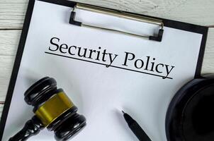 Top view of Security Policy text on white paper clipboard with gavel. security concept photo
