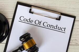 Top view of Code of Conduct text on clipboard with gavel on top. Code of Conduct concept. photo