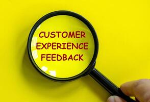 Top view of Customer Experience Feedback text on magnifying glass with yellow background. photo