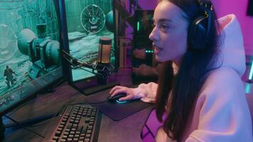 Caucasian addicted dependence female gamer girl woman streamer play at computer internet virtual gaming at home web battle online playing game at evening talking with microphone and headset video