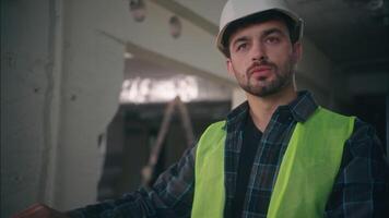 profesional caucásico inspector arquitecto contratista hombre chico técnico ingeniero masculino analizando sequía Plano constructor diseñador obrero mirando esquema inspeccionar edificio en construcción fabricación video