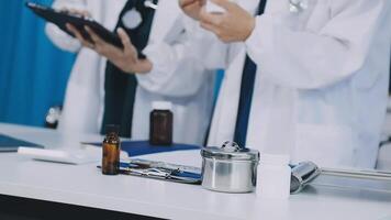 Two doctors in white coats standing at a table with a tablet video