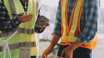 Two men in safety vests and hard hats are working on a house video