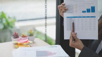 A woman in a business suit is holding a piece of paper with a graph on it video