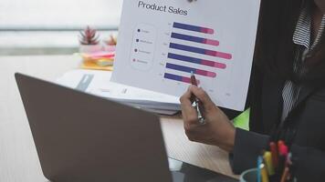 A woman in a business suit is holding a graph paper video