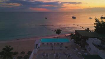Aerial view of a hotel with a rooftop pool on the beach in Punta Cana at sunrise video
