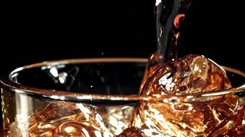 Coke is poured into a glass with ice. Filmed on a high-speed camera at 1000 fps. High quality FullHD footage video