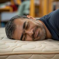 Customer enjoying comfort, lying on orthopedic mattress in furniture store photo