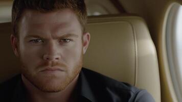 Portrait of a serious businessman sitting in a comfortable leather seat inside a private jet, luxury and convenience of first class travel photo