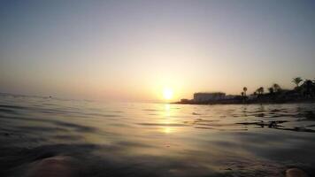 Man relaxing floating in a calm beach at sunset in summer - First person view video