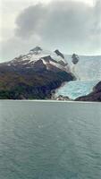 Glacier descending into fjord between rocky mountains in southern Patagonia video