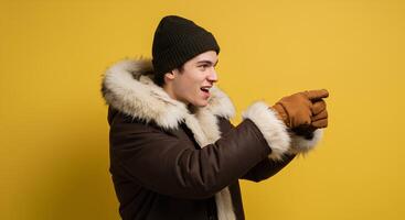 Man in a Brown Parka and Knitted Hat Points Enthusiastically photo