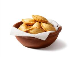 A bowl filled with empanadas on a white background photo