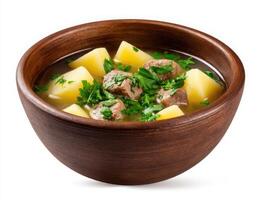 Meat stew with potatoes and parsley in a wooden bowl isolated on white background photo