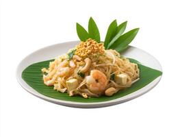 A plate with noodles, shrimp and peanuts on a leaf photo