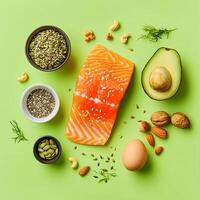 Salmon, almonds, eggs, nuts and other ingredients on a green background photo