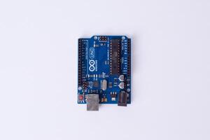 Malang, March 24, 2025. Top view of Arduino Uno microcontroller board on white background. DIY electronics, robotics, embedded system, prototyping hardware, open-source platform for coding. photo