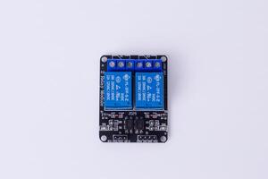 malang, marzo 24, 2025. parte superior ver de 2 canal relé módulo para microcontrolador 5v controlar tablero para inteligente hogar automatización, iot proyectos, electrónico traspuesta. blanco antecedentes. foto