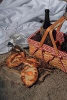 Closeup of wine picnic on beach with khachapuri pastry and strawberries photo