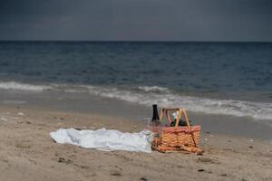 Minimalist coastal picnic setup with wine basket and khachapuri on sand. Beach Picnic by the Ocean photo