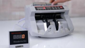 Automatic calculation. Electronic counter machine on the table. Small bill counter device showing the amount of counting paper money. Financial operations in bank. video