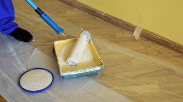 Painter put down roller into paint tray to renovate painting walls. Apartment decorating and home. Construction while renovating and improving. Close-up. video