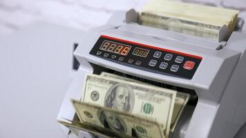 Money counting equipment for paper money calculation. Woman puts a pack of dollar banknotes to count. Automatic mechanism for bank financial operations. video