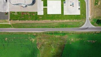 Industrial territory on green field. Flight over the field and car parkings of a modern factory. Cars and trucks on parking spaces. Aerial view. video
