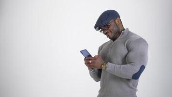 Black man in glasses texting on the phone. Portrait of a handsome afro american man using mobile phone typing sms message. Copy space. video