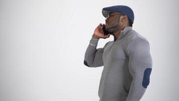 Smiling sportsman talking the phone in studio. Young afro american man with muscular body having a conversation and smiling. Profile view. Copy space. video