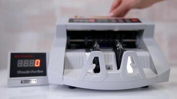 Electronic device is calculating fifty-euro bills. Woman puts paper banknotes into automatic counting machine. Automatic mechanism for bank financial operations. Currency exchange. video