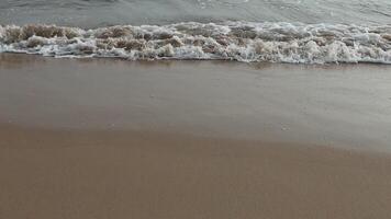 waves crashing on shore of sandy beach on a cloudy Day video