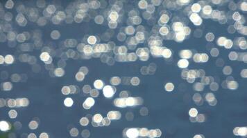 Soft sunlight gleaming across rippling water surface, creating mesmerizing bokeh effect with gentle, ethereal luminescence and tranquil visual texture. video