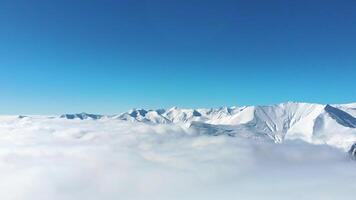 snowy mountains with mist and clouds form layers below snowy peaks.. Copy space banner time lapse of forming passing clouds in mountains. Kazbegi. Georgia caucasus mountains range video