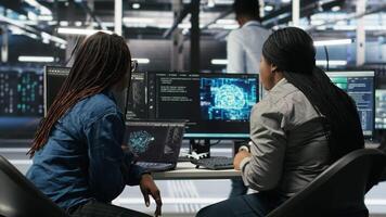 Data center coworkers doing brainstorming, using artificial intelligence machine learning models to configure equipment. IT experts cooperating in server farm, working on optimizing systems, camera B video
