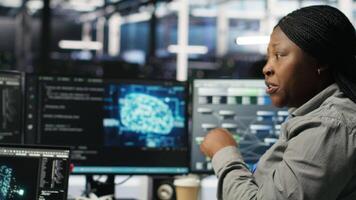 Data center engineering team deploying AI solutions optimizing gear. Server hub teamworking colleagues working together, using artificial intelligence to minimize systems downtime, camera B video