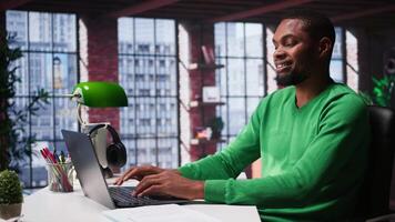 African american remote worker at home doing online research, writing down and gathering important data. Teleworker focused on reading articles, daily assignments at home. Camera B. video